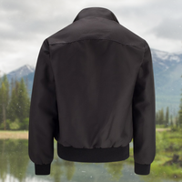 Schwarze Bomberjacke aus Nylon vor Berglandschaft, modisch und wetterfest.