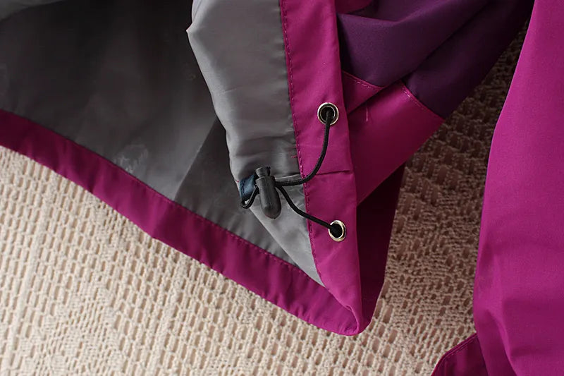 Lila Regenjacke mit grauem Innenfutter, Kordelzug, wetterfest, Outdoor-Bekleidung.