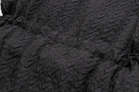 Schwarzer, strukturierter Stoff mit geprägtem Muster, ideal für Mode und Textildesign.