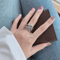 Silberner Stapelring auf Hand, Damenmode, Schmuck, elegantes Design, Jeanshintergrund.