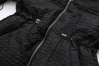 Schwarze Steppjacke mit Reißverschluss, strukturierte Oberfläche, modische Winterbekleidung.