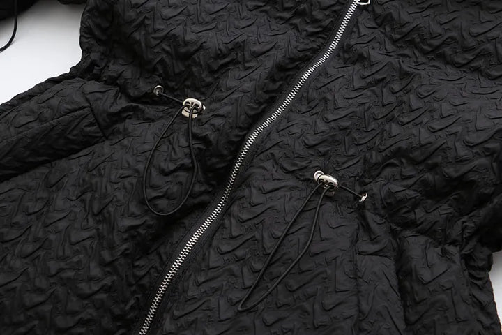 Schwarze Steppjacke mit Reißverschluss, strukturierte Oberfläche, modische Winterbekleidung.