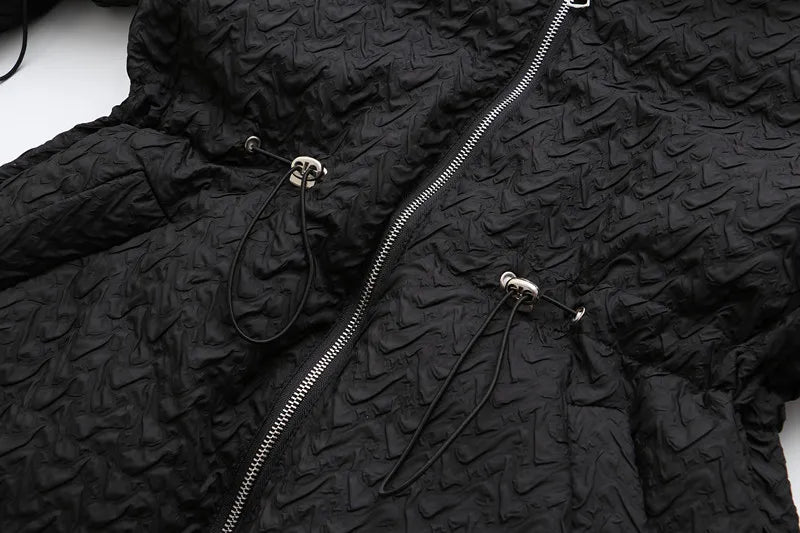 Schwarze Steppjacke mit Reißverschluss, strukturierte Oberfläche, modische Winterbekleidung.