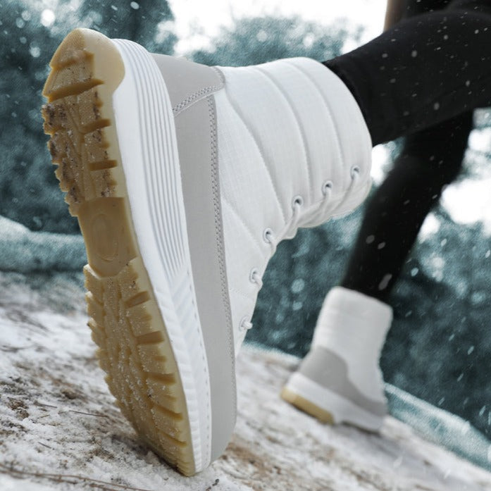 Weiße Winterstiefel mit rutschfester Sohle im Schnee, modisch und funktional.