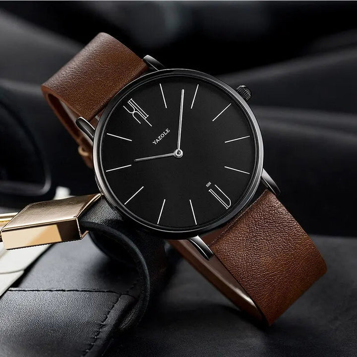 Minimalistische Herrenuhr mit schwarzem Zifferblatt und braunem Lederarmband, elegant und modern.