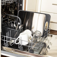 Offene Spülmaschine mit Geschirrkorb, Besteck, Tassen und Schneidebrett aus Edelstahl.