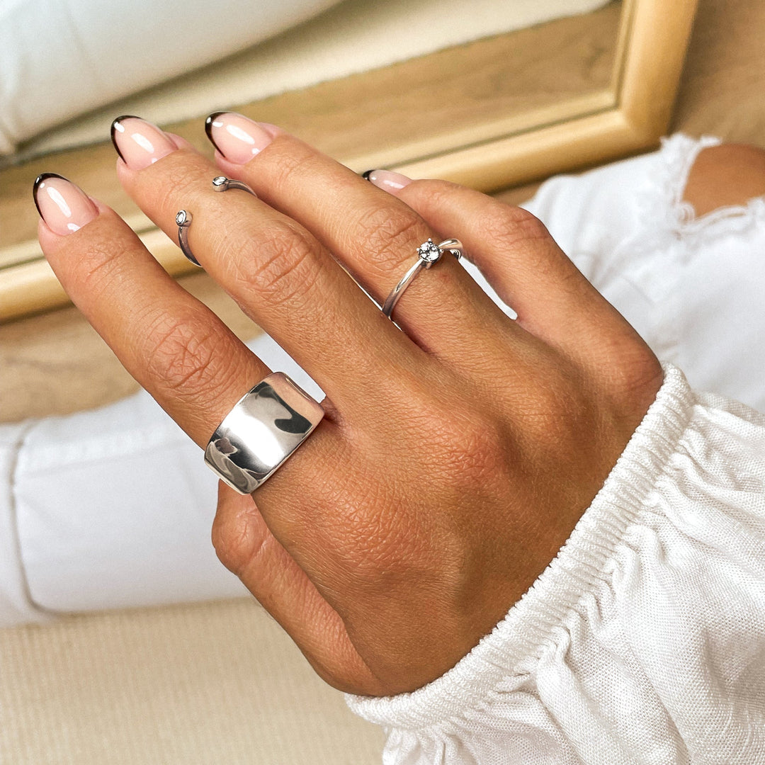 Silberringe Damenhand, modische Fingerringe, glänzend, minimalistisch, Schmucktrends 2023.