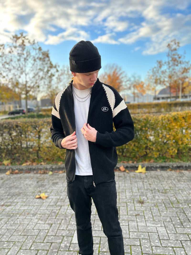 Mann in schwarzer Strickjacke und Mütze, Herbstlandschaft, Freizeitmode, Outdoor-Kleidung.