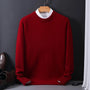Roter Herrenpullover aus Wolle, elegant, auf Holzkleiderbügel, vor schwarzem Hintergrund.
