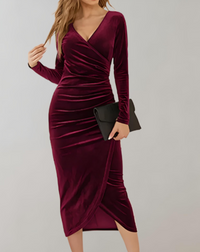 Frau in elegantem, langem, weinrotem Samtkleid mit V-Ausschnitt und schwarzer Clutch.