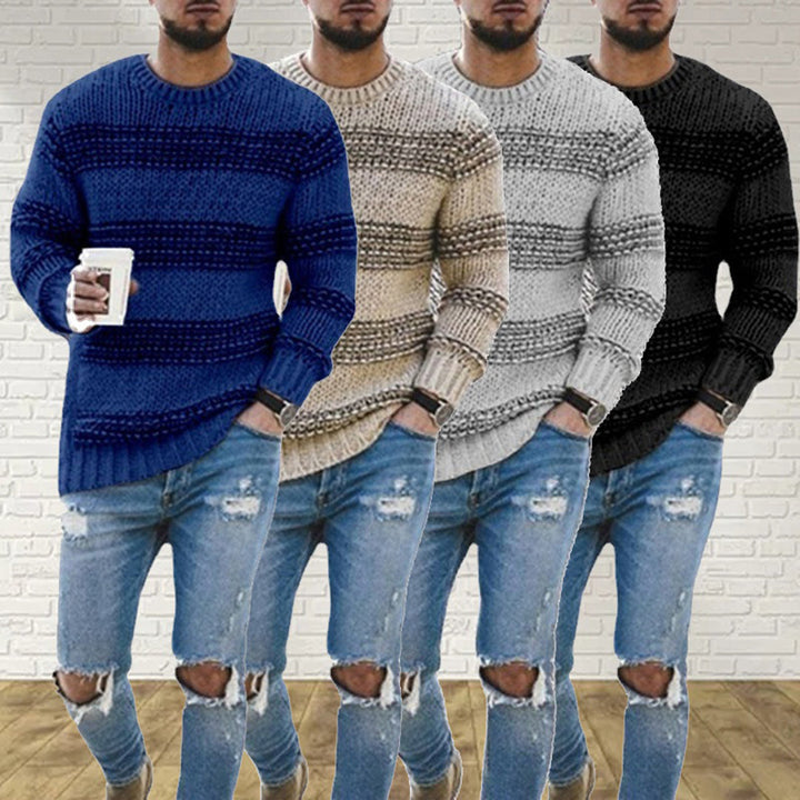 Vier Herrenpullover, gestrickt, in Blau, Beige, Grau und Schwarz, vor weißer Ziegelwand.