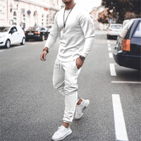 Mann in weißem Trainingsanzug auf Straße, modisch, sportlich, urbaner Stil, Freizeitkleidung.