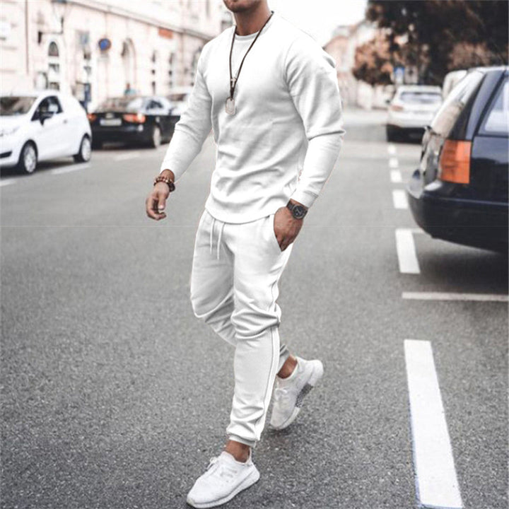 Mann in weißem Trainingsanzug auf Straße, modisch, sportlich, urbaner Stil, Freizeitkleidung.