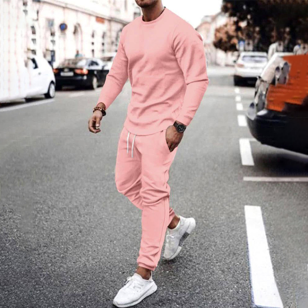 Mann in rosa Trainingsanzug auf Straße, modische Sportbekleidung, urbaner Stil, Herrenmode.