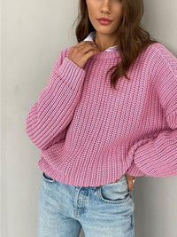 Frau in rosa Strickpullover, lässig, Crewneck, kombiniert mit blauer Jeans, modisch.