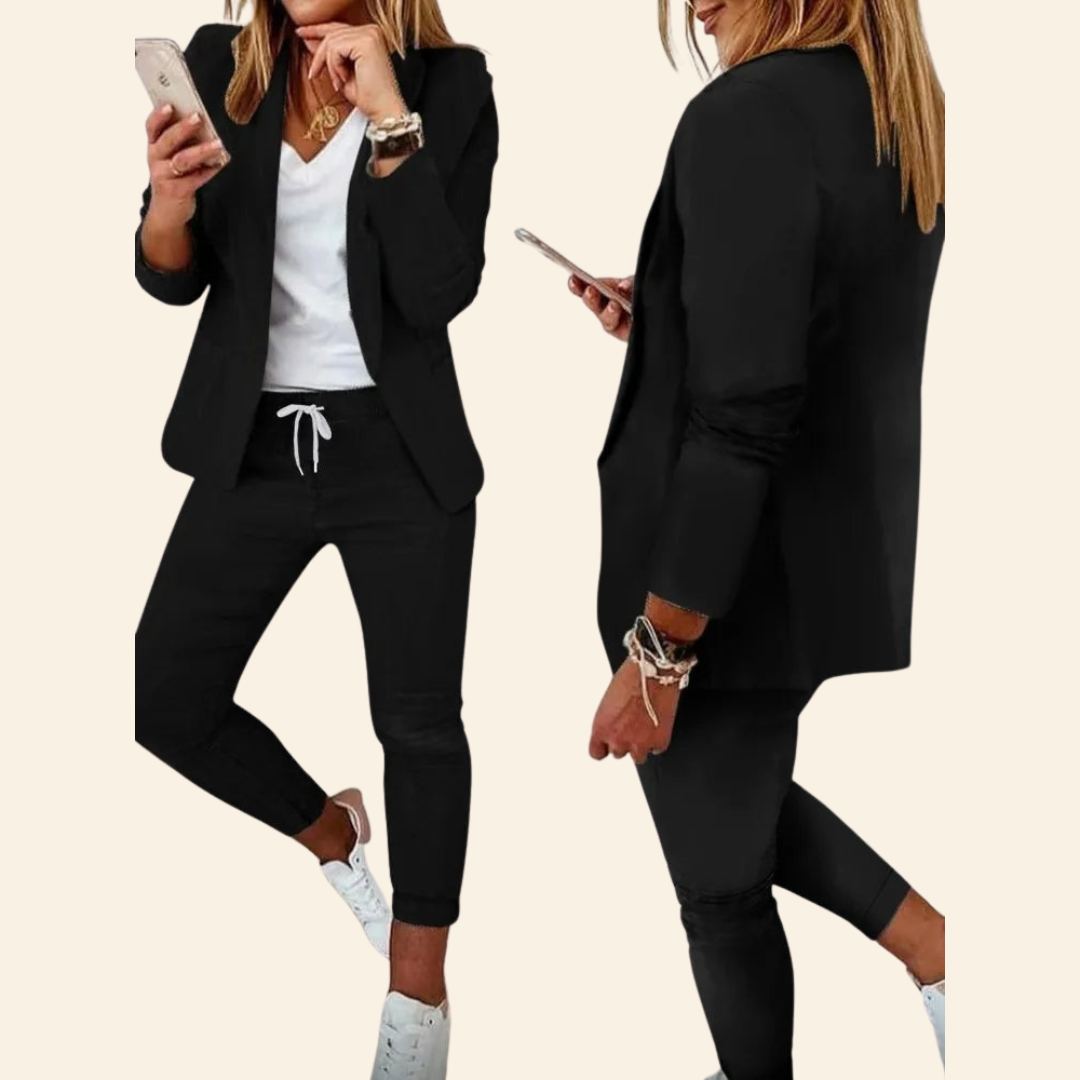 Frau im schwarzen Blazer und Jogginghose, weißes T-Shirt, Smartphone, lässiger Business-Look.