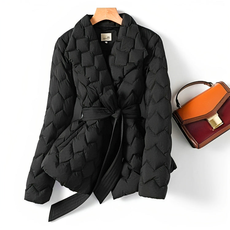 Schwarze gesteppte Damenjacke mit Gürtel, elegant, modisch, Herbst-Winter, neben brauner Handtasche.
