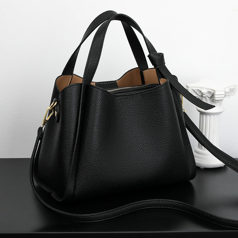 Schwarze Lederhandtasche mit Schulterriemen, elegant, modisch, Damenaccessoire.