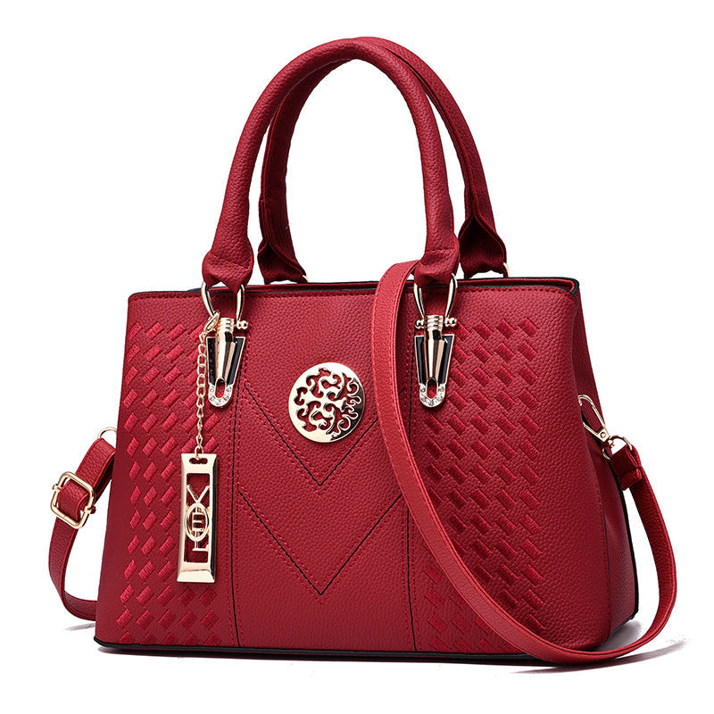 Rote Damenhandtasche aus Leder mit Schulterriemen und goldenen Details, elegant und modisch.
