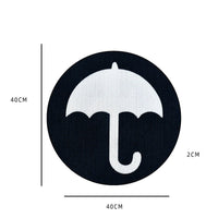 Schwarzer runder Teppich mit weißem Regenschirm-Design, 40x40x2 cm, modernes Wohnaccessoire.