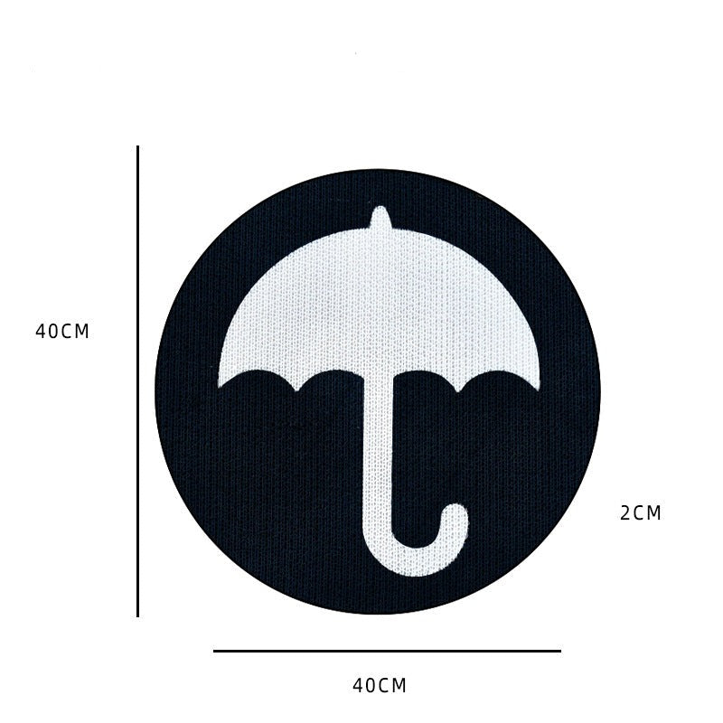 Schwarzer runder Teppich mit weißem Regenschirm-Design, 40x40x2 cm, modernes Wohnaccessoire.