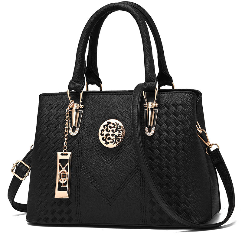 Schwarze Damenhandtasche aus Leder mit goldenen Details und abnehmbarem Schulterriemen.