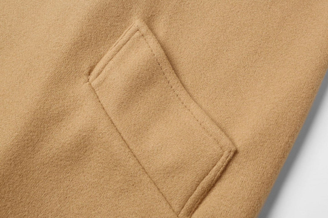 Beige Wollmantel Detailansicht, Nahaufnahme einer Tasche, hochwertige Wintermode, elegantes Design.