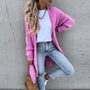 Frau in rosa Strickjacke, weiße Bluse, zerrissene Jeans, braune Tasche, lässiger Stil.