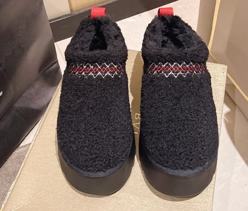 Schwarze Hausschuhe aus Fleece mit rotem Muster, rutschfeste Sohle, gemütlich und warm.