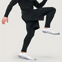 Mann in schwarzer Sportbekleidung, Kompressionsleggings, weiße Socken, dynamische Pose.