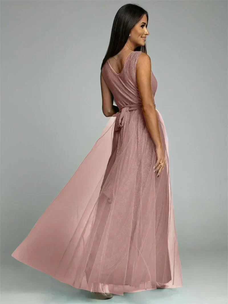 Frau in langem, rosa Abendkleid aus Chiffon, ärmellos, elegant, Rückansicht.