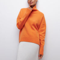 Frau trägt orangefarbenen Rollkragenpullover, Damenmode, Herbstkleidung, Strick, elegant.