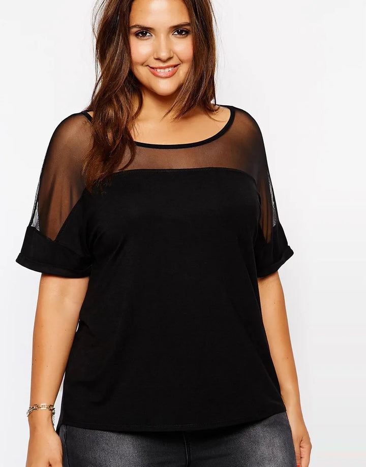 Frau in schwarzem T-Shirt mit transparenten Ärmeln, lächelnd, Plus-Size-Mode, Freizeitkleidung.