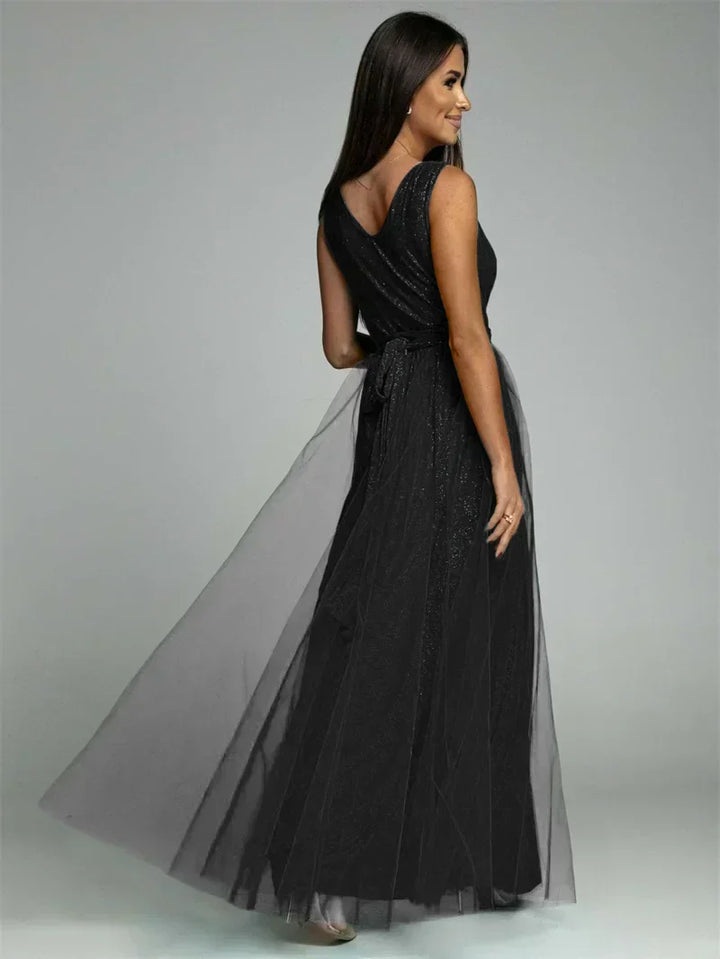 Frau in elegantem, schwarzem Abendkleid aus Tüll, ärmellos, bodenlang, glamouröses Design.
