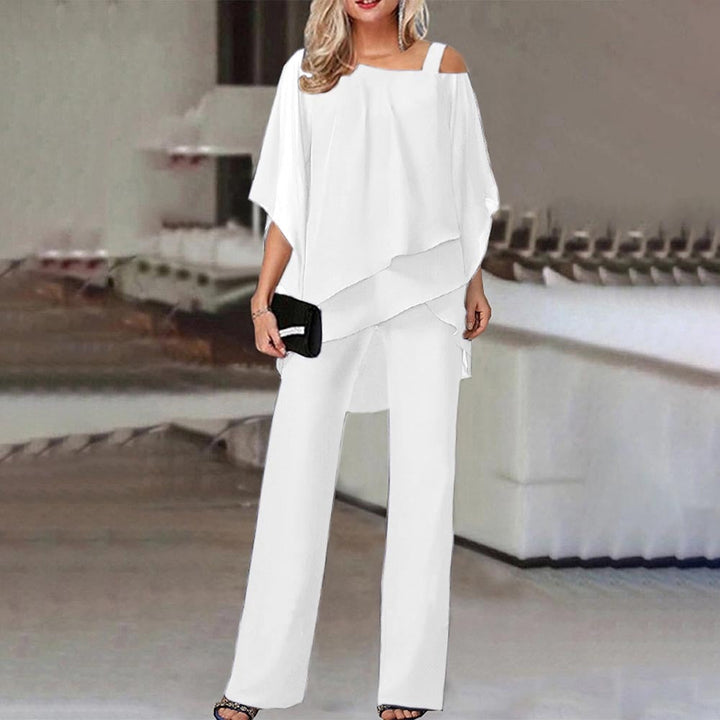 Frau in eleganter weißer Off-Shoulder-Bluse und Hose, Abendmode, schwarze Clutch.