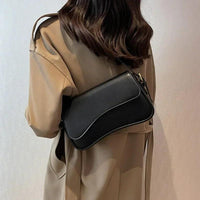 Frau mit schwarzer Lederhandtasche, Umhängetasche, elegantes Design, modischer Stil.