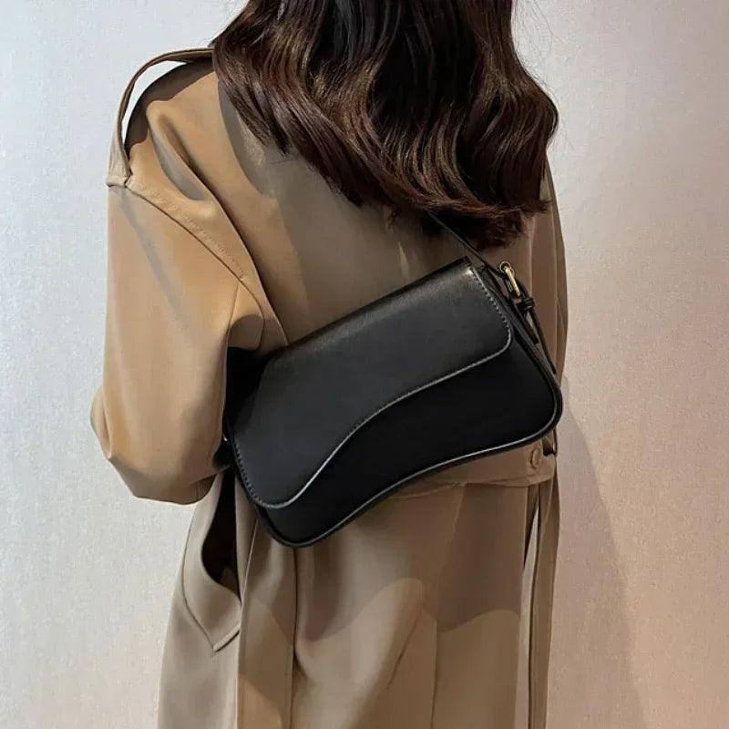 Frau mit schwarzer Lederhandtasche, Umhängetasche, elegantes Design, modischer Stil.