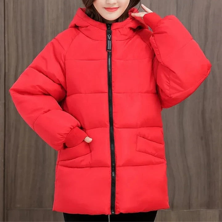 Frau in roter Daunenjacke mit Kapuze, Wintermode, warm, stilvoll, Reißverschluss, Damenbekleidung.