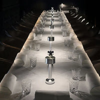 Langer, elegant gedeckter Tisch mit Kristallgläsern und modernen Salz- und Pfefferstreuern.