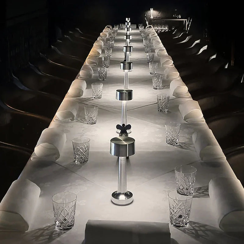 Langer, elegant gedeckter Tisch mit Kristallgläsern und modernen Salz- und Pfefferstreuern.