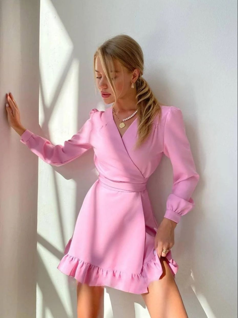 Frau in rosa Wickelkleid mit Rüschen, elegantes Design, Tageslicht, modisches Outfit.