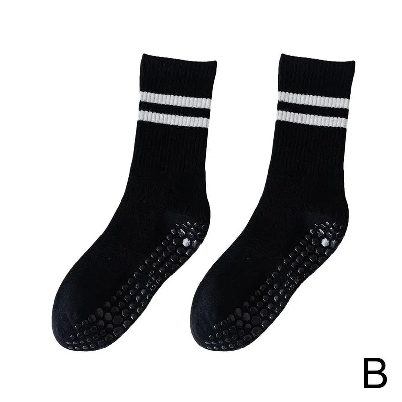 Schwarze rutschfeste Socken mit weißen Streifen, ideal für Sport und Freizeit.