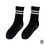 Schwarze rutschfeste Socken mit weißen Streifen, ideal für Sport und Freizeit.