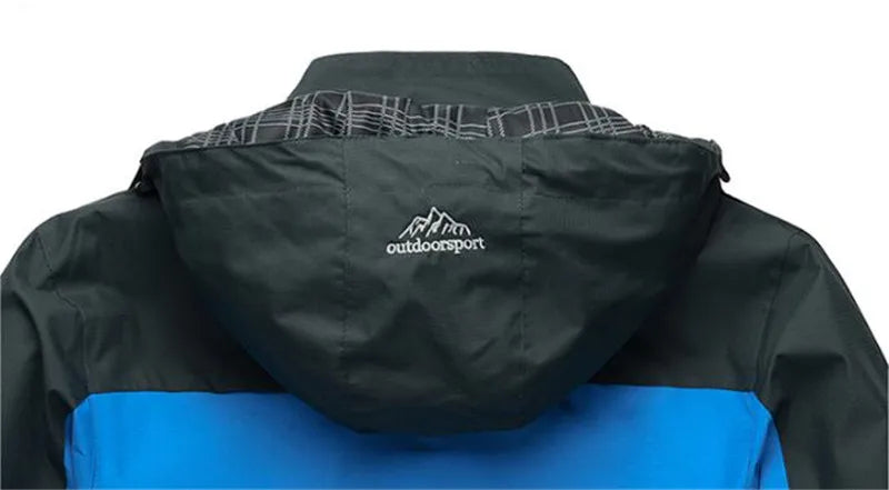 Blau-schwarze Outdoorjacke mit Kapuze, winddicht, wasserdicht, ideal für Wandern und Trekking.