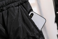 Schwarze Jogginghose mit Smartphone in der Tasche, atmungsaktives Material, sportlich.