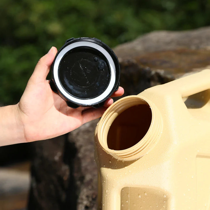 Beige Wasserkanister aus Kunststoff mit abgenommenem Deckel, Outdoor, Camping, robust.