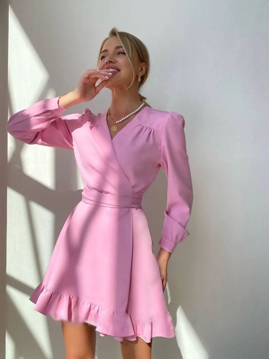 Frau in rosa Kleid mit Rüschen, lächelnd, Sonnenlicht, elegantes Outfit, Modefotografie.