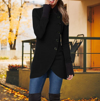Frau in schwarzem Mantel, Herbst, Jeans, Stiefel, stilvolle Herbstmode, draußen, Laub im Hintergrund.