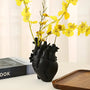 Schwarze Herzvase mit gelben Orchideen, modernes Design, Dekoration, Wohnzimmer, Tischdeko.