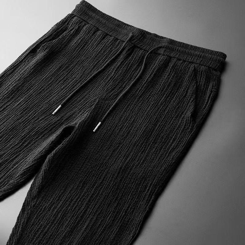 Schwarze Herren-Jogginghose, plissierter Stoff, Kordelzug, bequem, modisch, Freizeitkleidung.